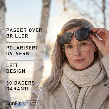 Kvinne med briller løfter SunFit fit-over-solbriller i vintersol over snø